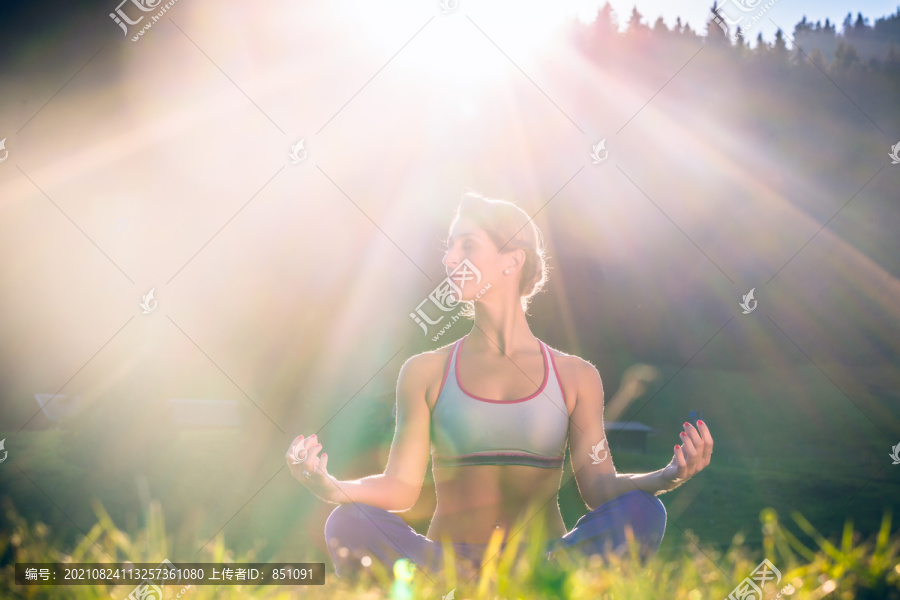 女人在夕阳下做瑜伽，在背光的情况下