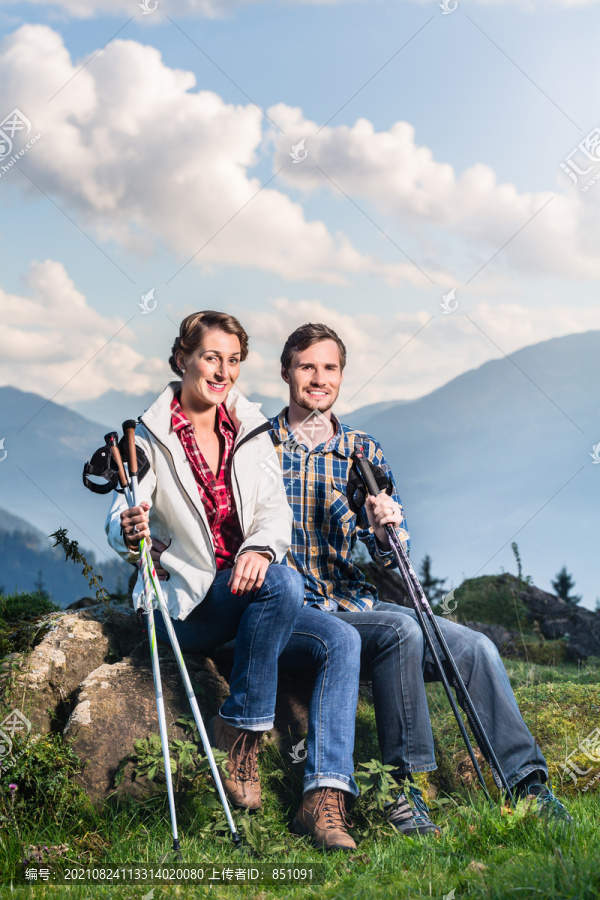 一对夫妇在阿尔卑斯山徒步旅行欣赏风景