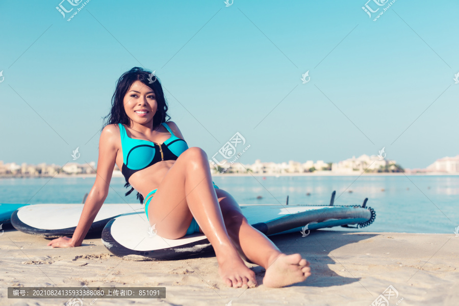 冲浪板上城市海滩上靠近水面的冲浪女孩
