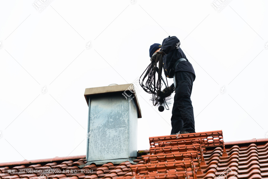 烟囱清扫器站在家里工作的屋顶上