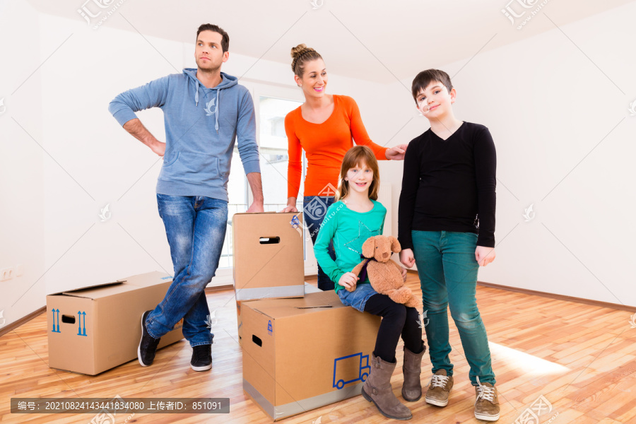 在新家或新房子里搬箱子的家人四处看看