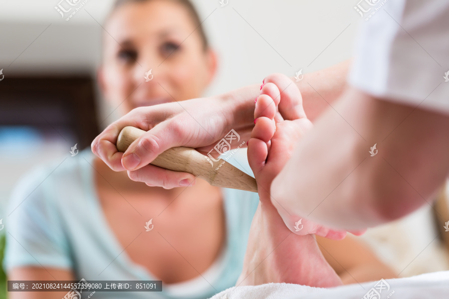 足底按摩或用木棍压脚的妇女