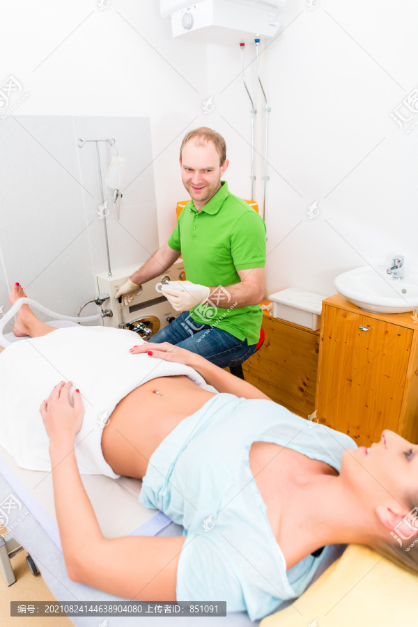 在结肠治疗中的妇女与替代医生躺在长凳上练习