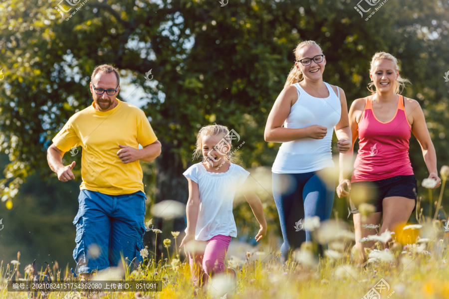 一家人在鲜花盛开的草地上跑步