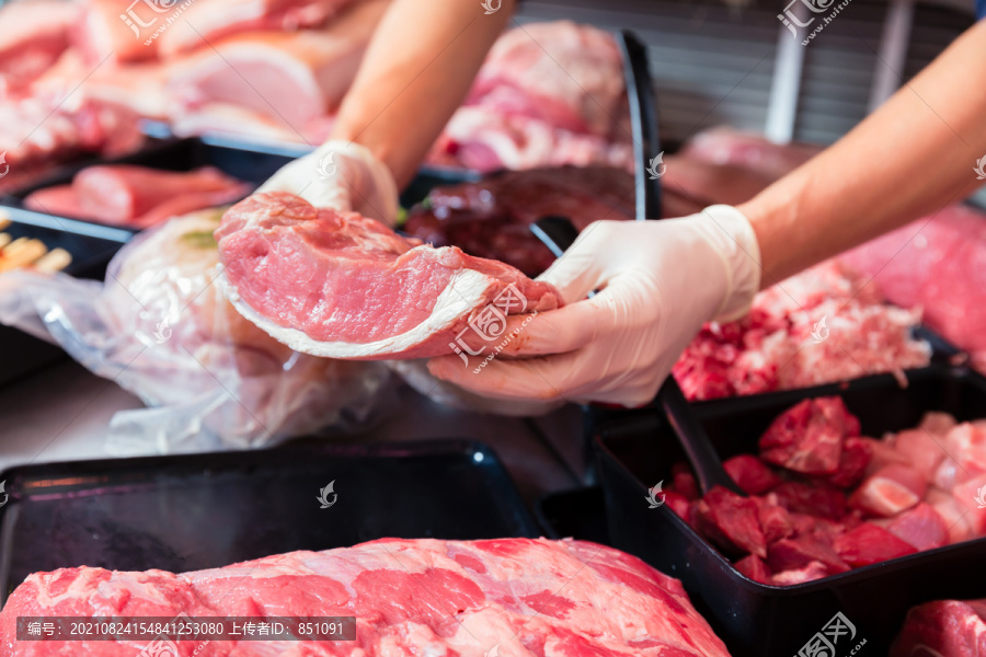 肉店陈列的肉被女售货员放进去，特写