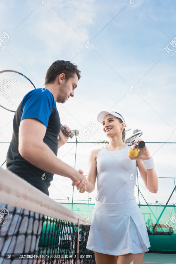 网球运动员男女在赛后在网前握手