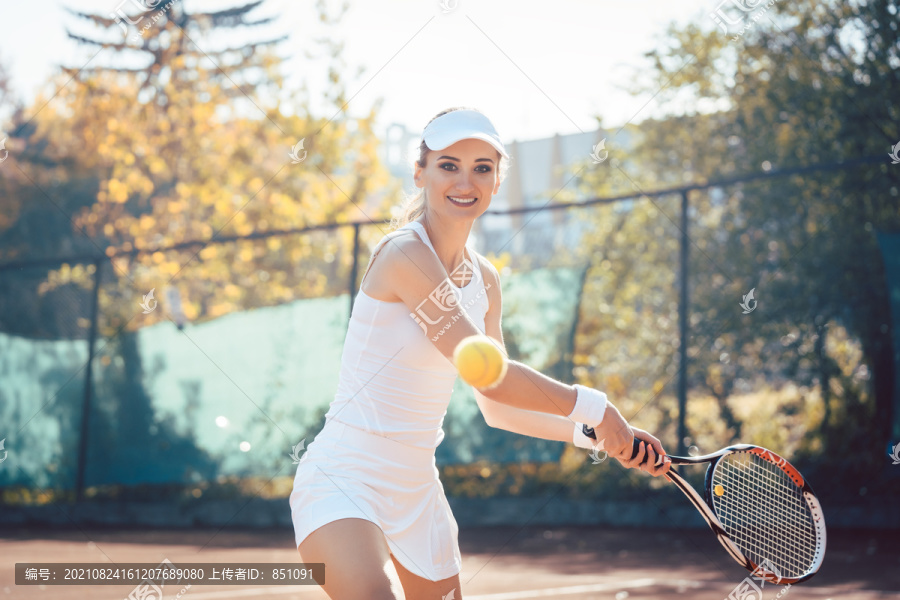 在球场上打网球的女子击球