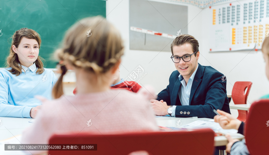 学生和老师围坐在书桌旁进行团队合作练习