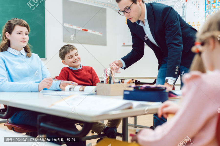 学生和老师围坐在书桌旁进行团队合作练习