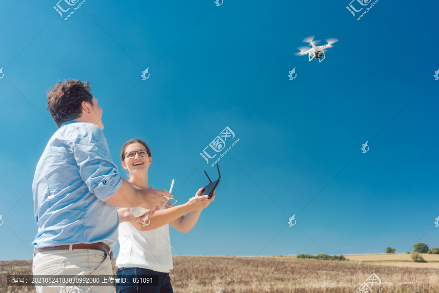 机组人员或操作无人机的男女人员利用无人机拍摄照片或电影