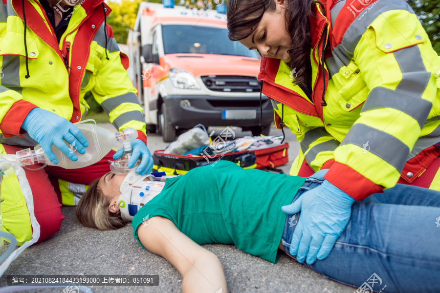 急救医生对摩托车事故后受伤的妇女进行急救