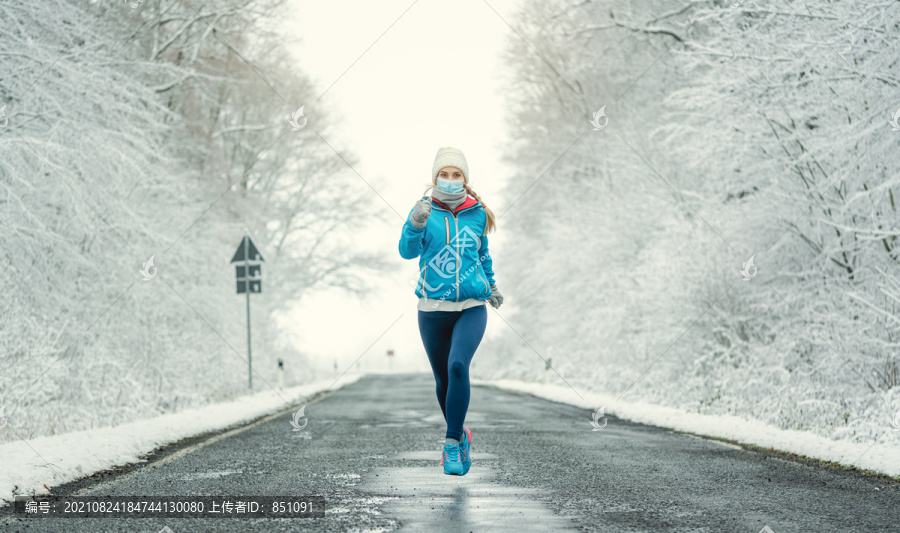 雪地景观中2019冠状病毒疾病的女性跑步或戴面罩慢跑