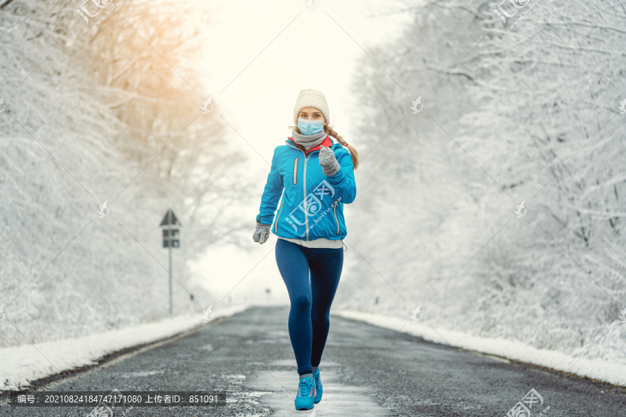 雪地景观中2019冠状病毒疾病的女性跑步或戴面罩慢跑