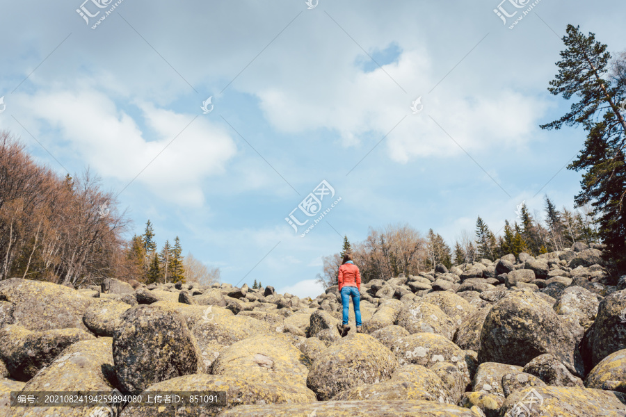 站在岩石上在野外徒步旅行的女人