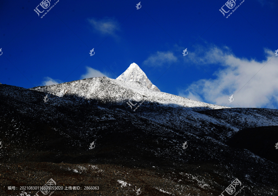 西藏蓝天下一座三角形雪山山峰