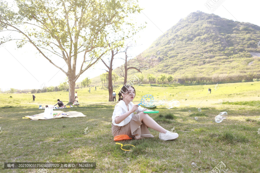 草坪上玩泡泡机的美女