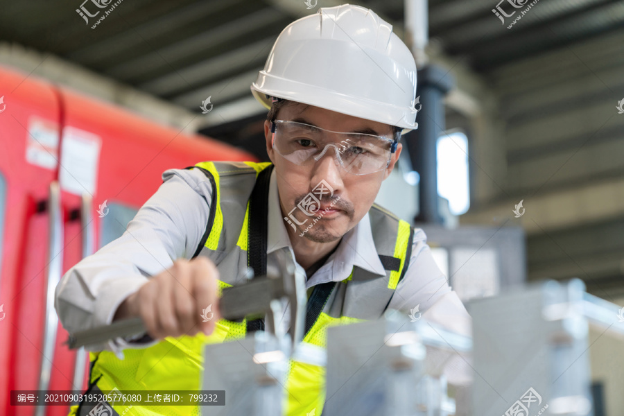 工程师穿保护工作服戴着安全帽在工厂工作
