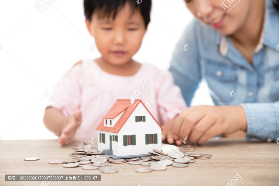 美元硬币上放着的小房子模型