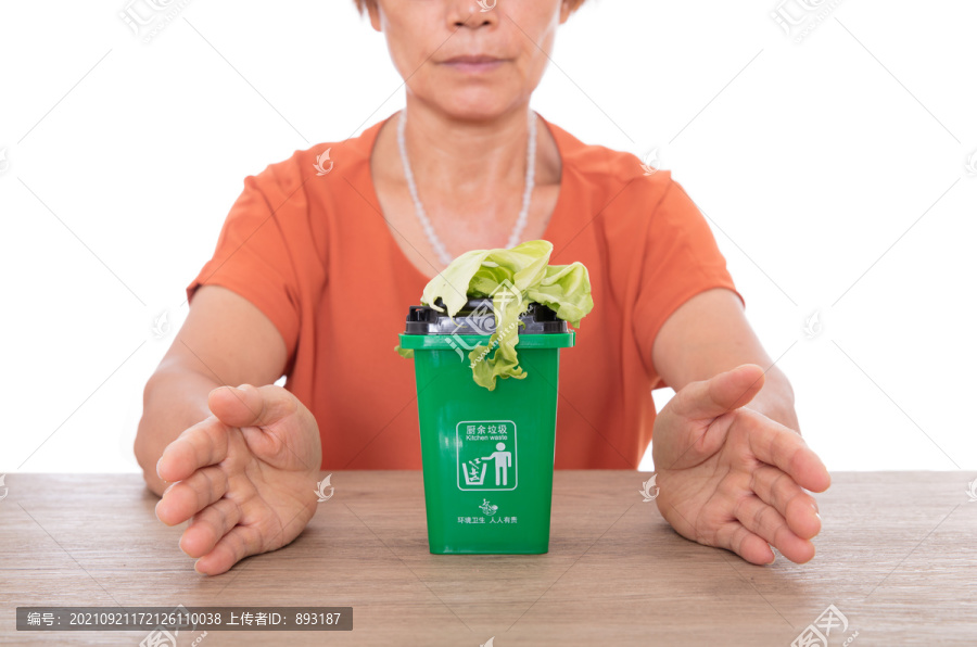 双手呵护着绿色的厨余垃圾桶和菜