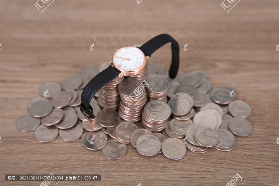 一堆美元硬币上放着一块腕表