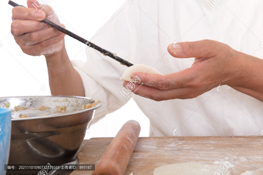 把饺子陷放到饺子皮上进行包饺子