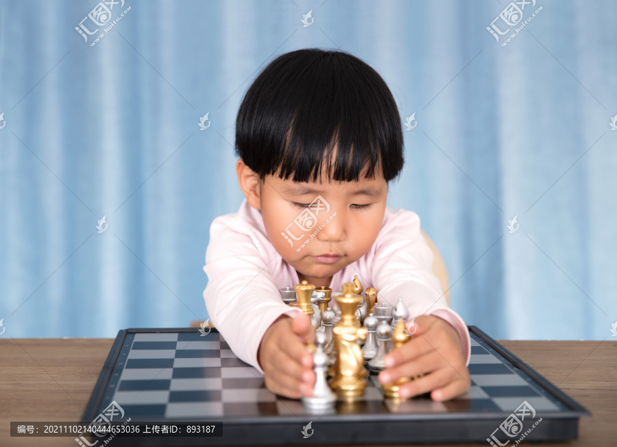 双手抱着国际象棋棋盘上的棋子