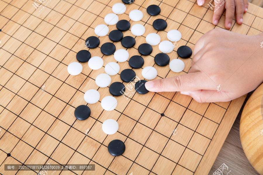 手指导着小孩的手下围棋