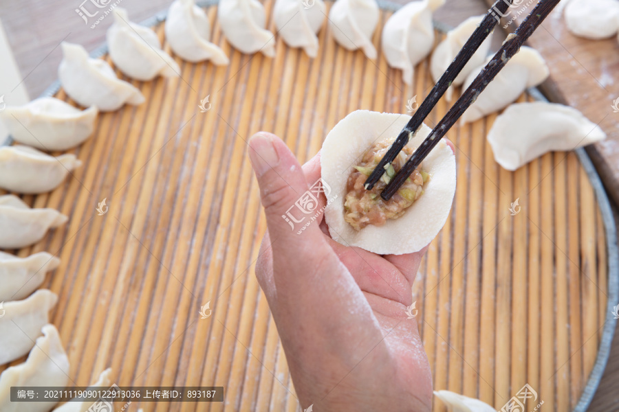 中国人正在包肉馅白面饺子