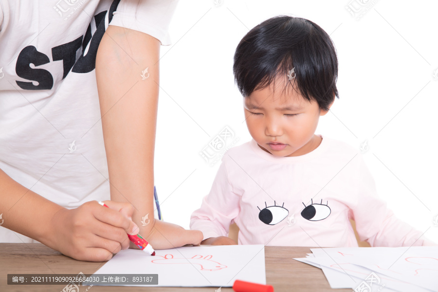 老师在认真的辅导小女孩画画