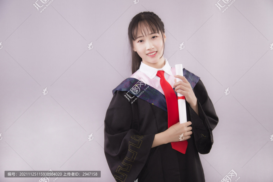 纯色背景下穿着学士服的女孩