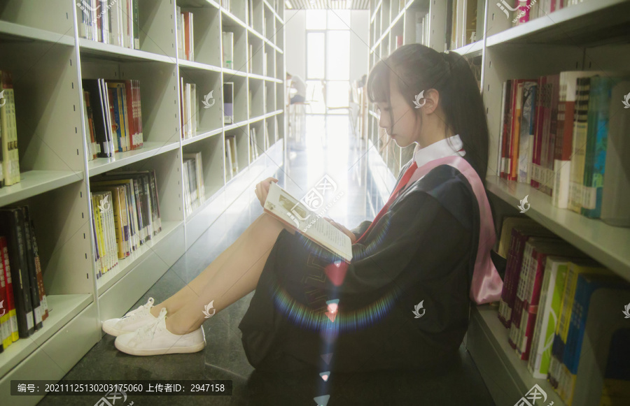 图书馆里穿着学士服的女孩