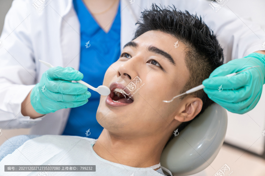 年轻男子在牙科诊所治疗牙齿