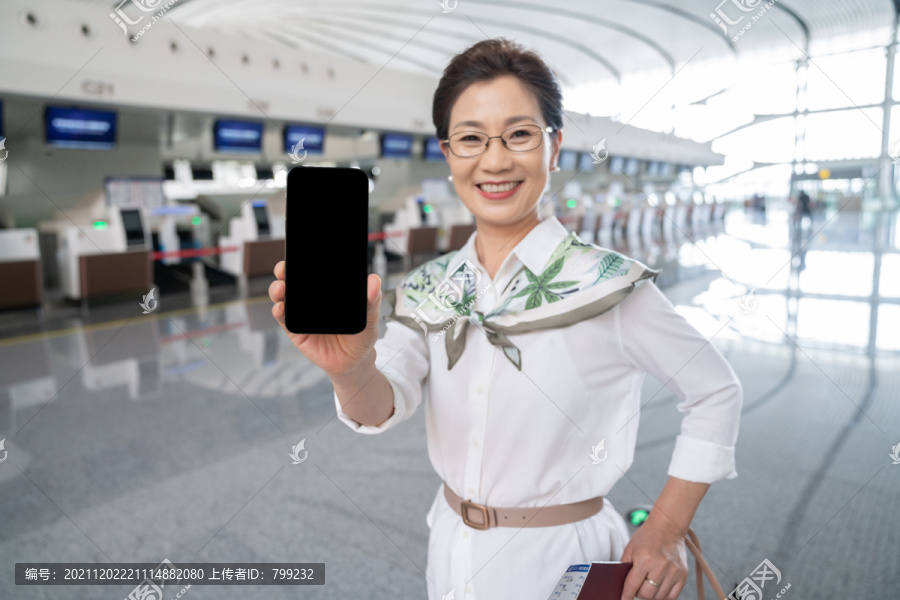 老年女人在机场展示手机