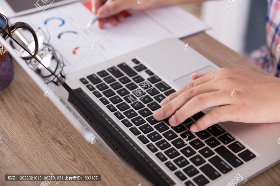 一双手在笔记本电脑键盘上打字