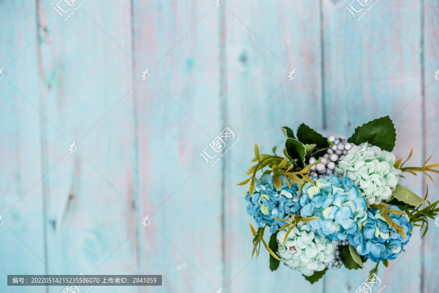 蓝色风格木桌面和花束背景