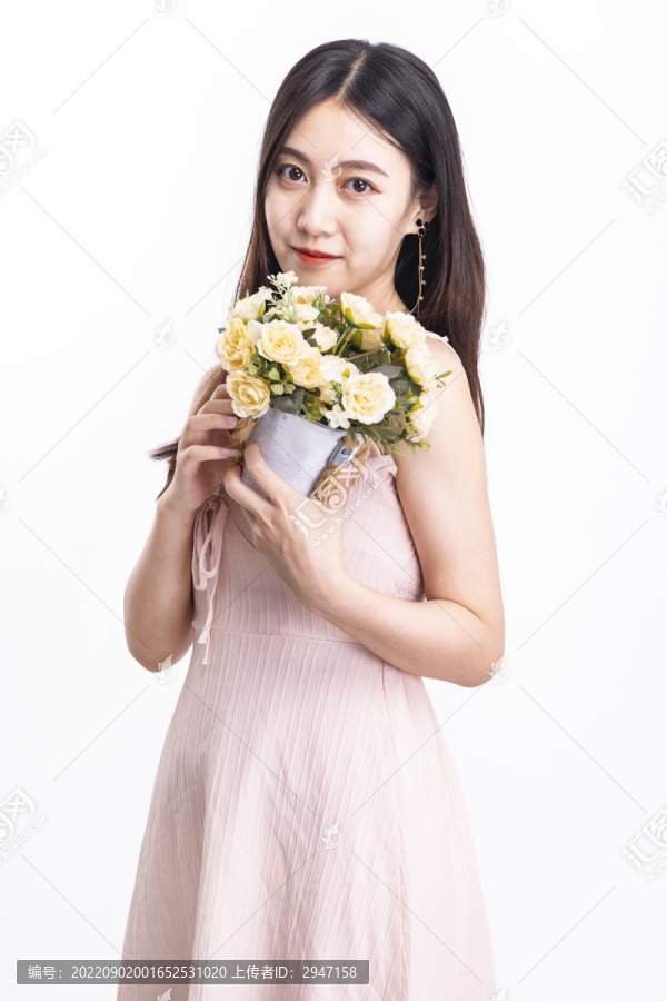 穿粉色连衣裙捧着一盆花的女人