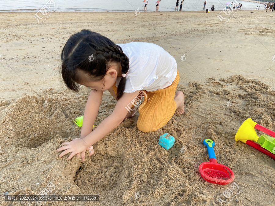 在沙滩玩沙的女孩