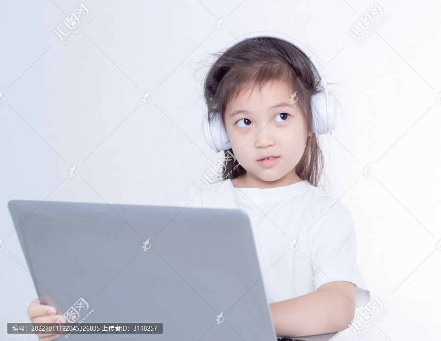 戴着耳机使用电脑的小女孩