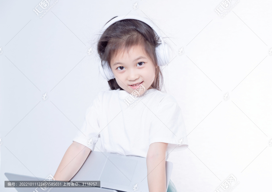 戴着耳机使用电脑的小女孩