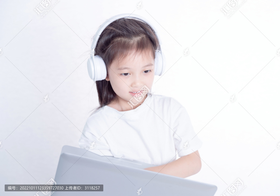 戴耳麦使用电脑的小女孩