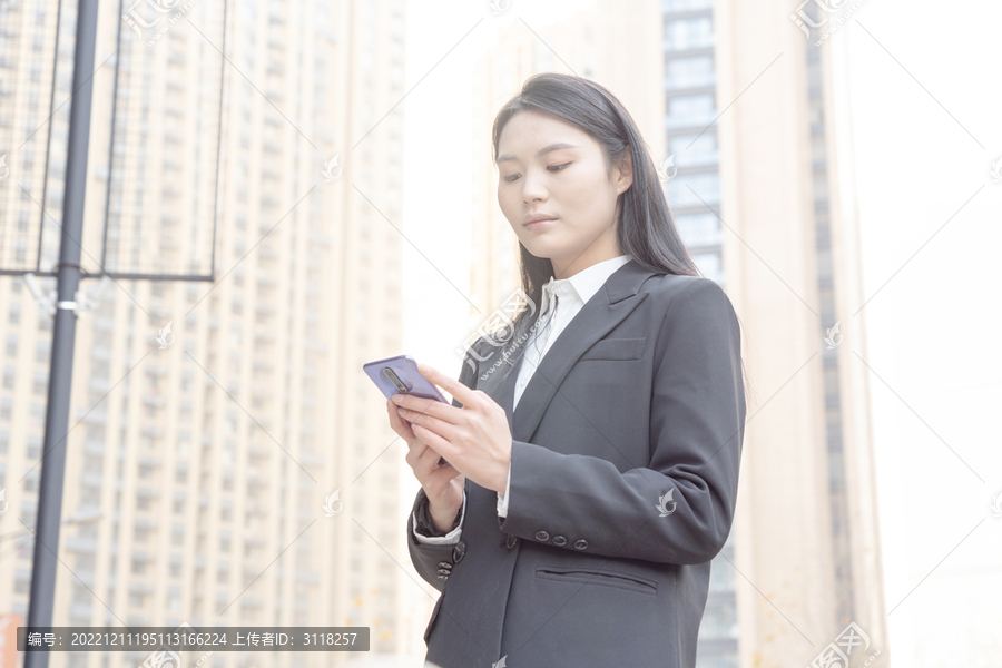 街头使用手机的西装女性