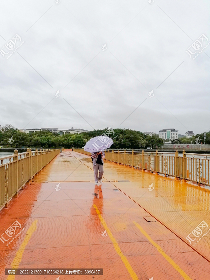 撑紫色伞走在橙色浮桥上的人