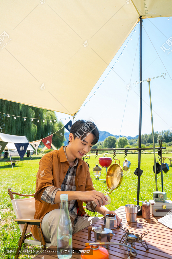 男孩坐天幕下煮咖啡