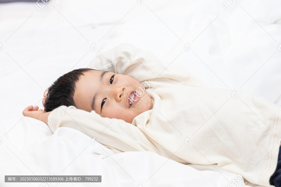 一个小男孩躺在舒适的床上