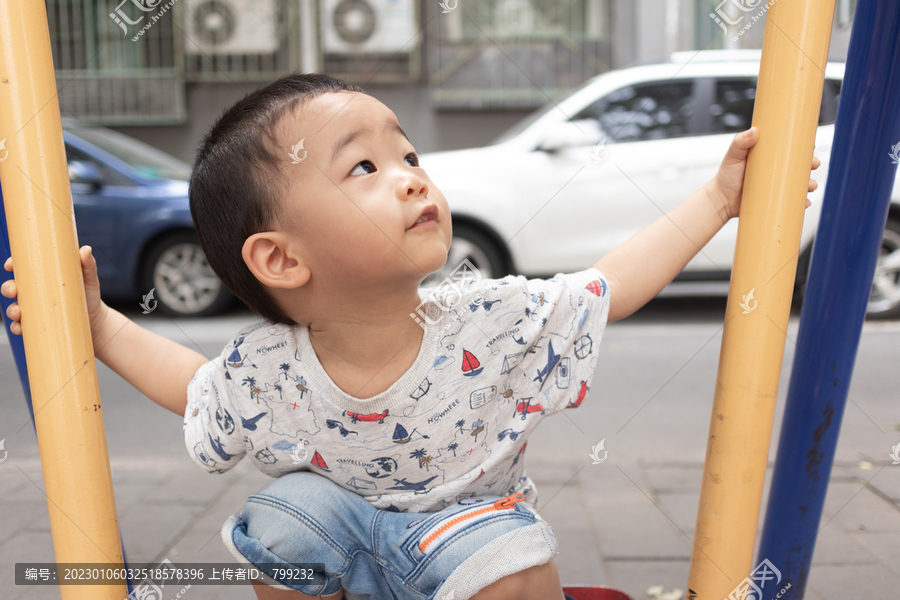 一个小男孩在院子里玩健身器械