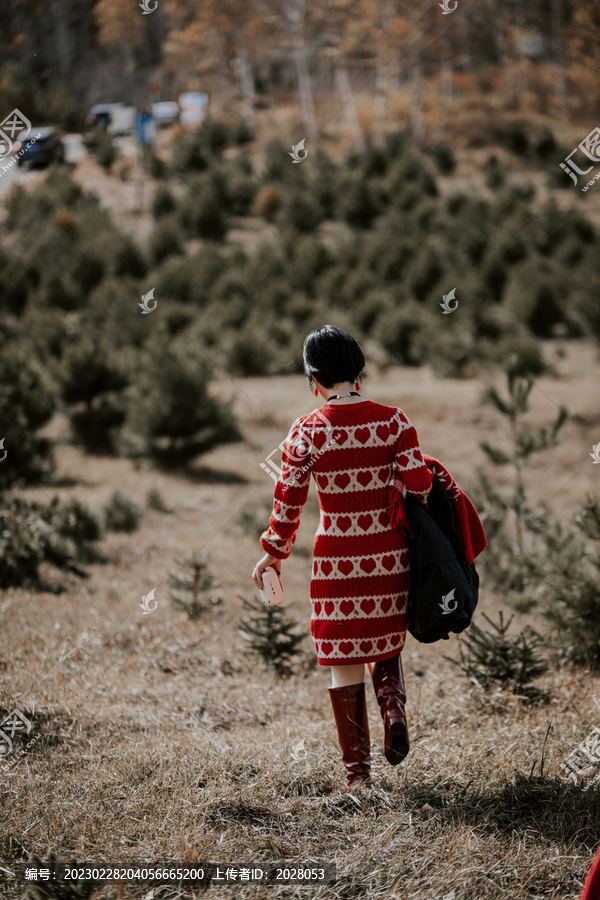 秋季穿红色毛衣行走的女性