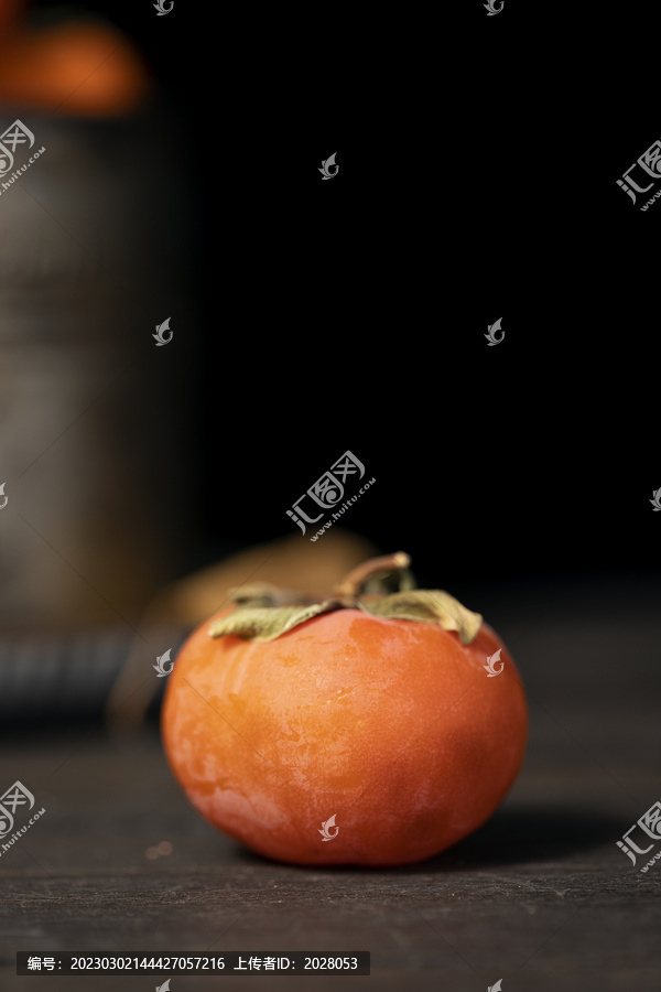 木桌上的一颗霜降柿子特写图片
