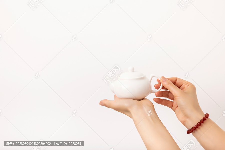 女子手拿白色小茶壶