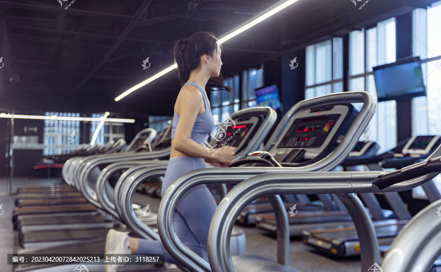 健身房使用跑步机的运动装女性