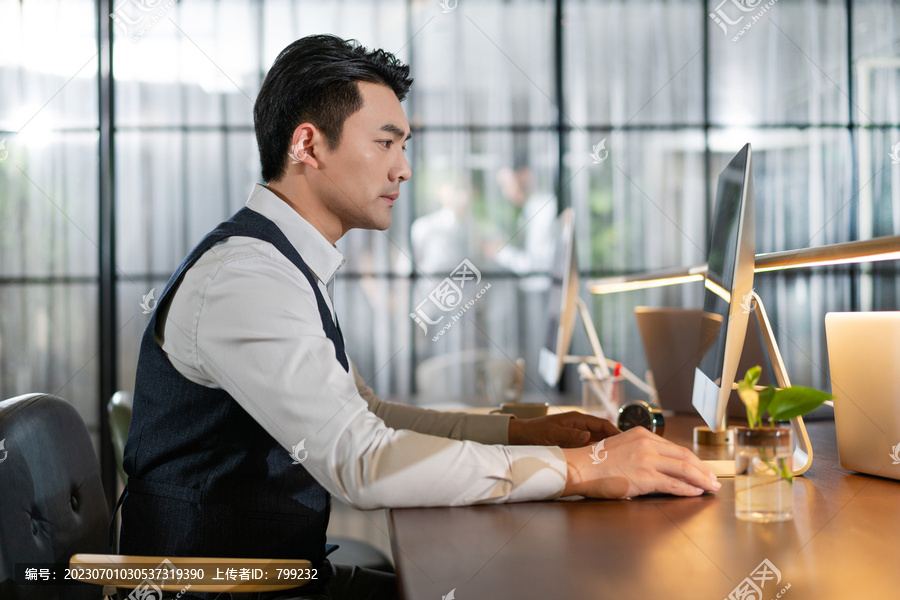 商务男士在办公桌前专注看电脑工作